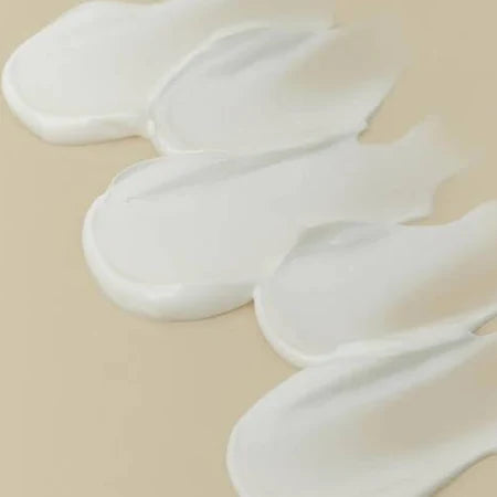 White cream or lotion swatches on a beige background