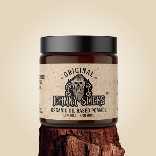 Jar of Johnny Slicks organic oil-based pomade on a wooden block with a beige background