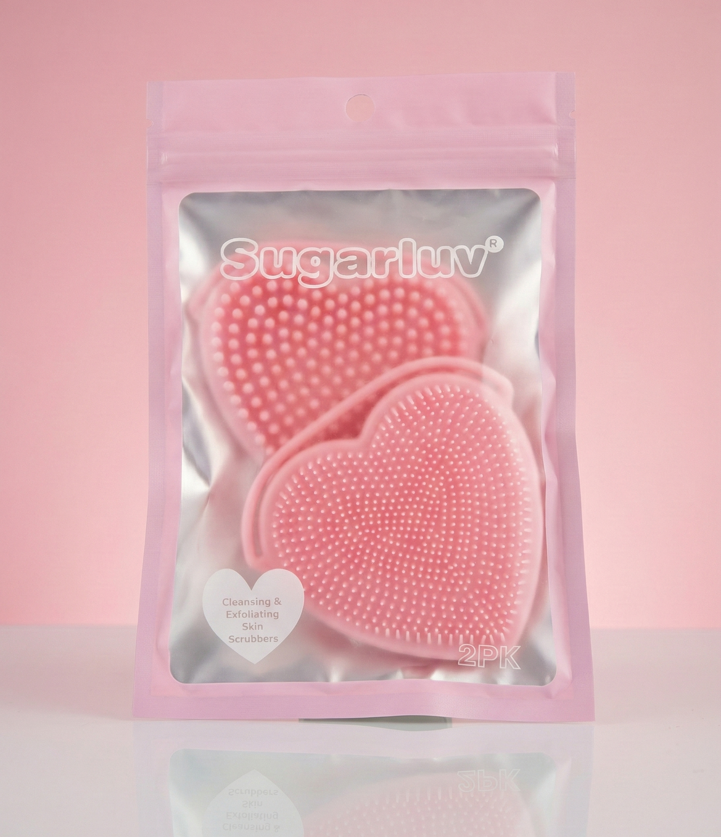 SugarLuv - Heart Shaped Silicone Face Scrubbers 2 Pack Pink heart-shaped scrubbers in a clear package with 'Sugarluv' branding on a pink background.