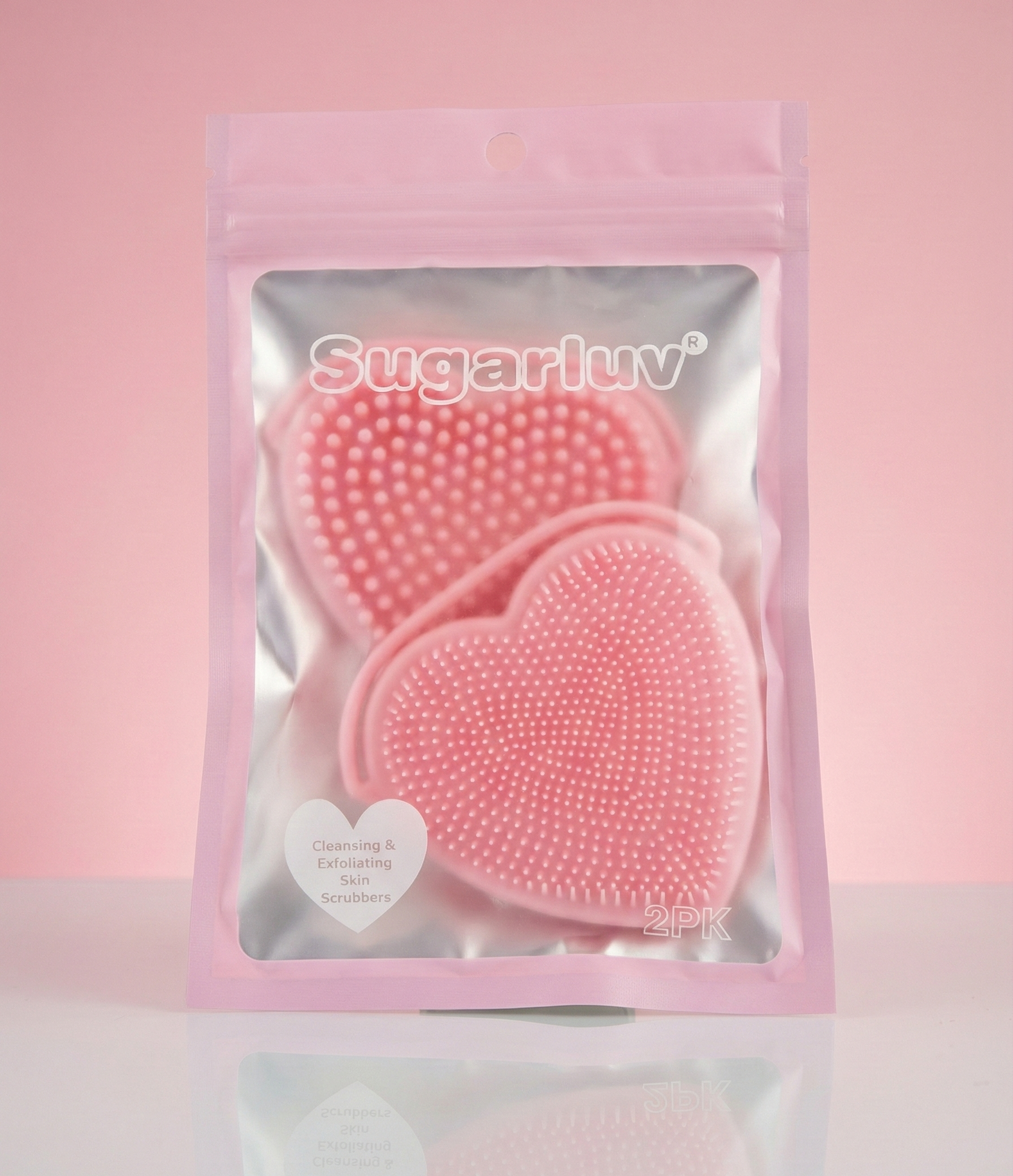SugarLuv - Heart Shaped Silicone Face Scrubbers 2 Pack Pink heart-shaped scrubbers in a clear package with 'Sugarluv' branding on a pink background.