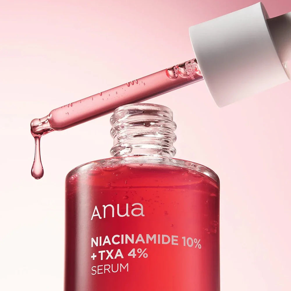 Red serum bottle with dropper labeled 'Anua' on a pink background