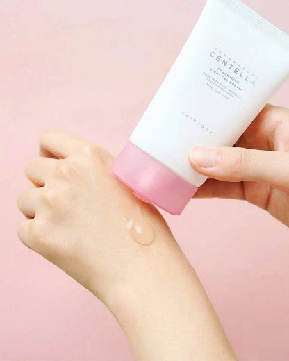 Hand applying madagascar centella poremizing light gel cream to a wrist with a pink background